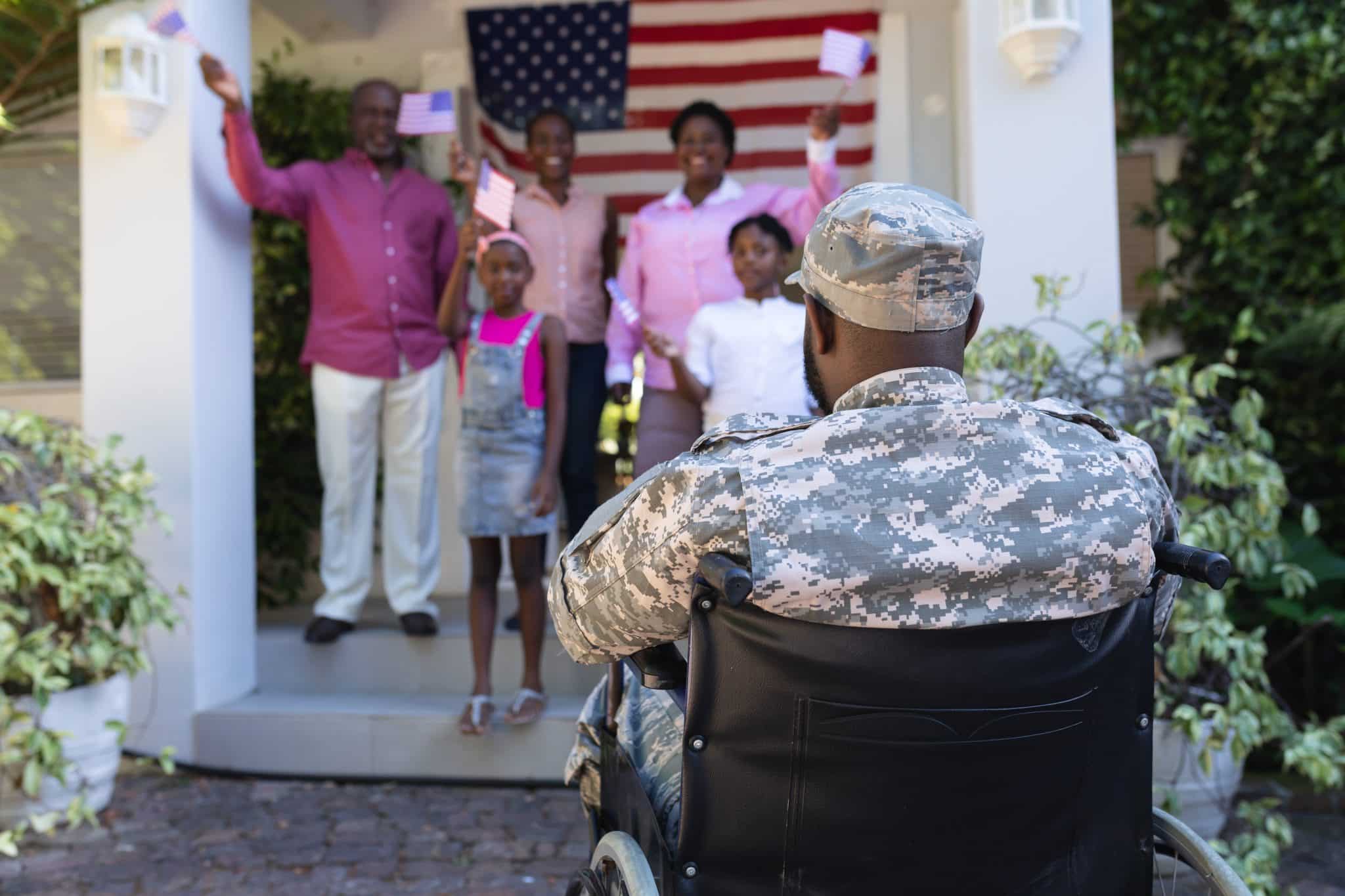 African american soldier father in wheelchair greeting smiling three generation family outside home. soldier returning home to family.